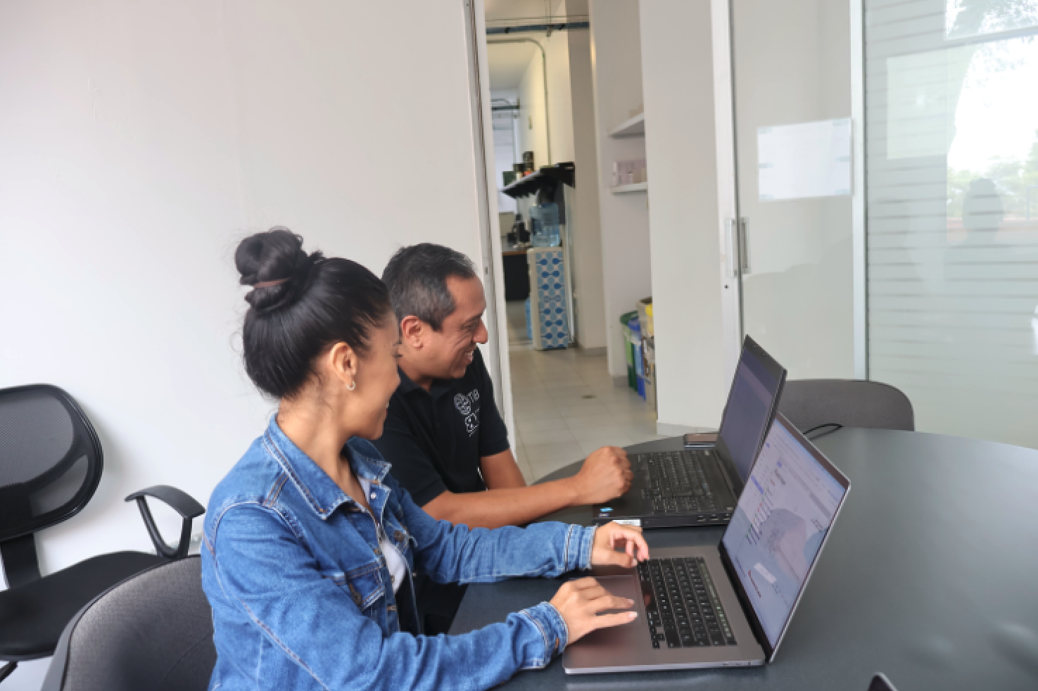 Shirley and Alfredo collaborating together with their laptops.